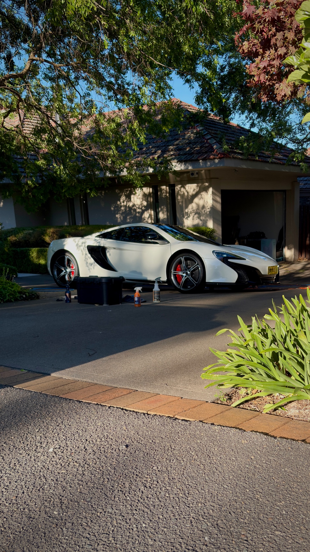 White McLaren 650S receiving a full detail on customer's driveway