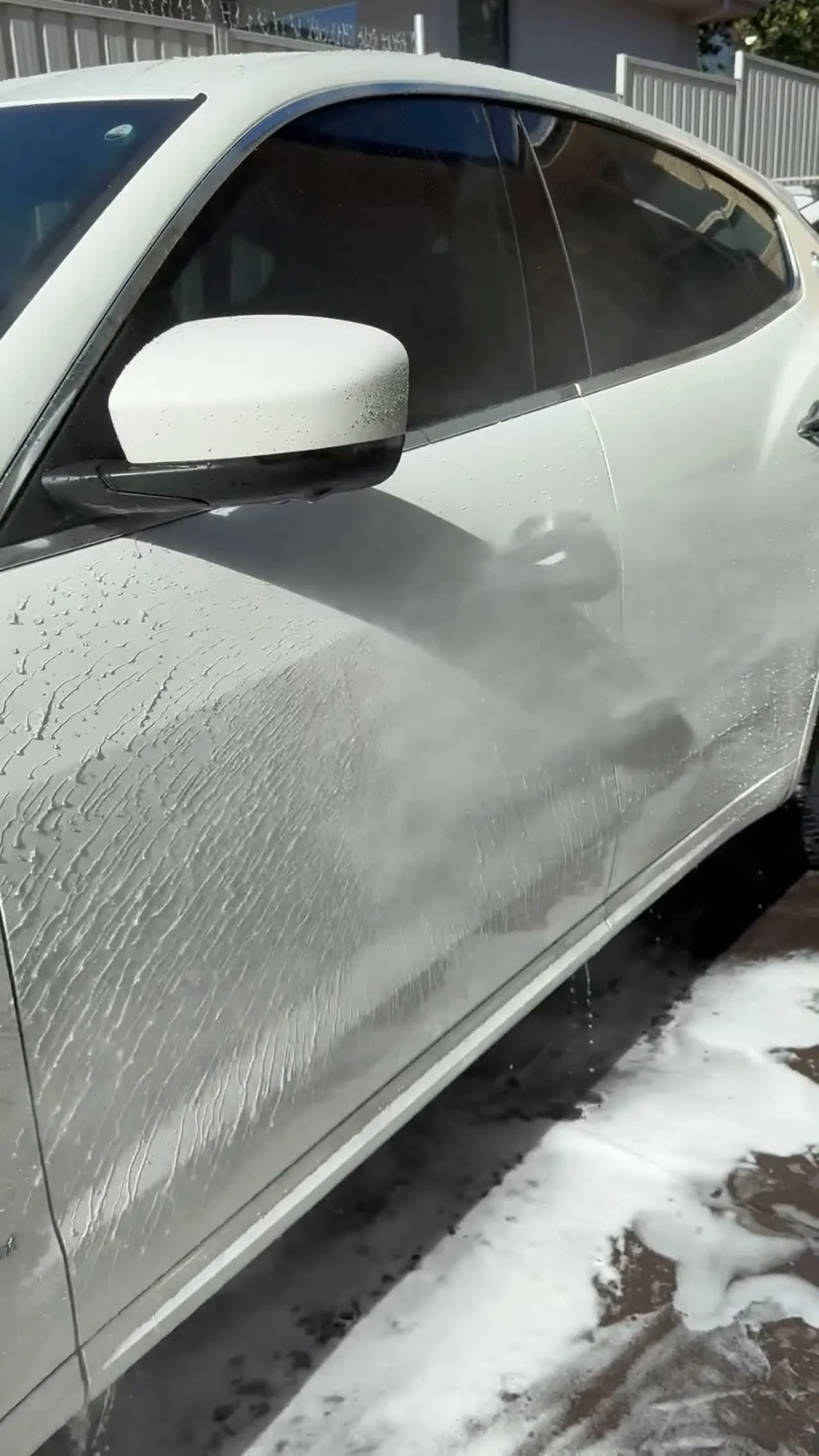 Water beading tightly on a freshly ceramic-coated white car