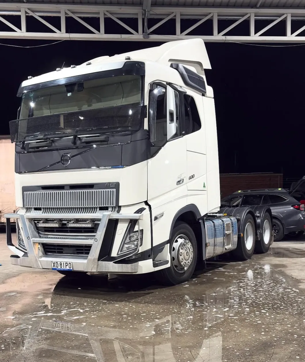 A white prime mover washed down, standing on wet concrete at night